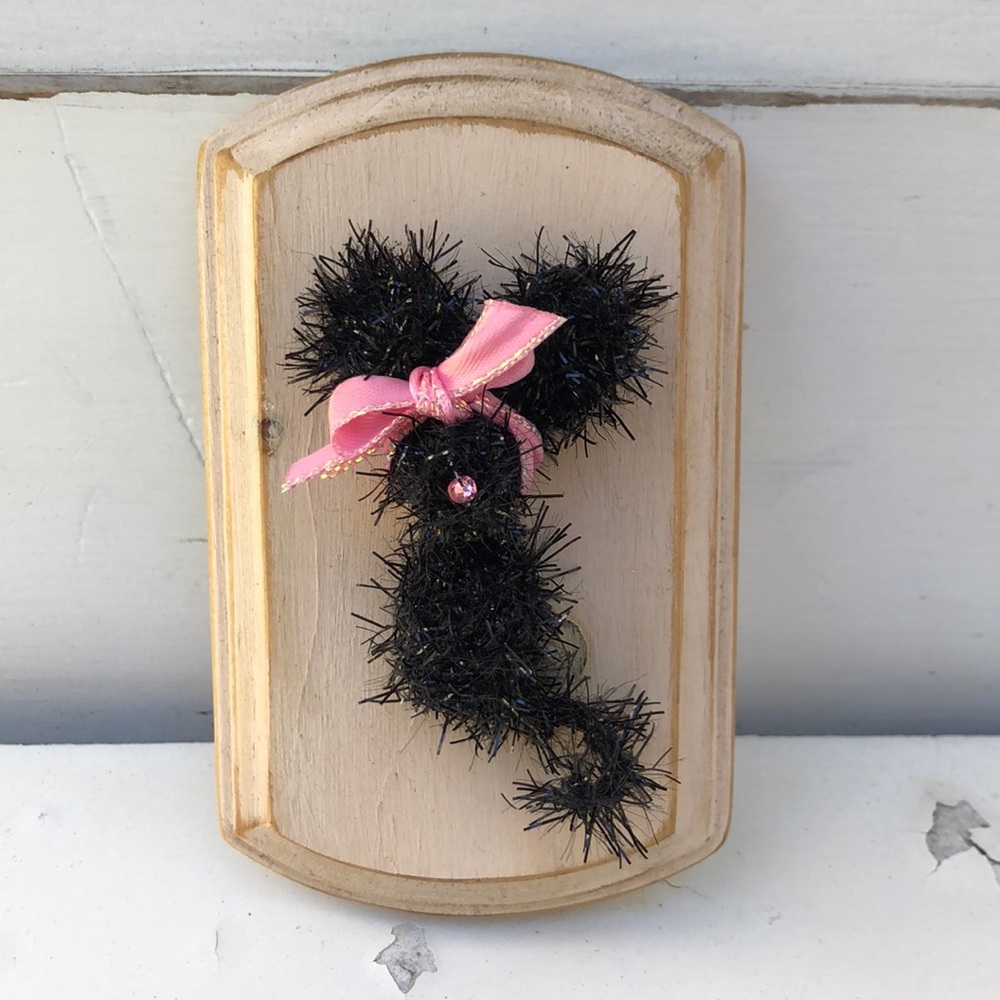 Crocheted tiny mouse on a wood plaque